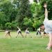 Kids stretching exercises in a park guided by a coach, promoting fitness and fun.